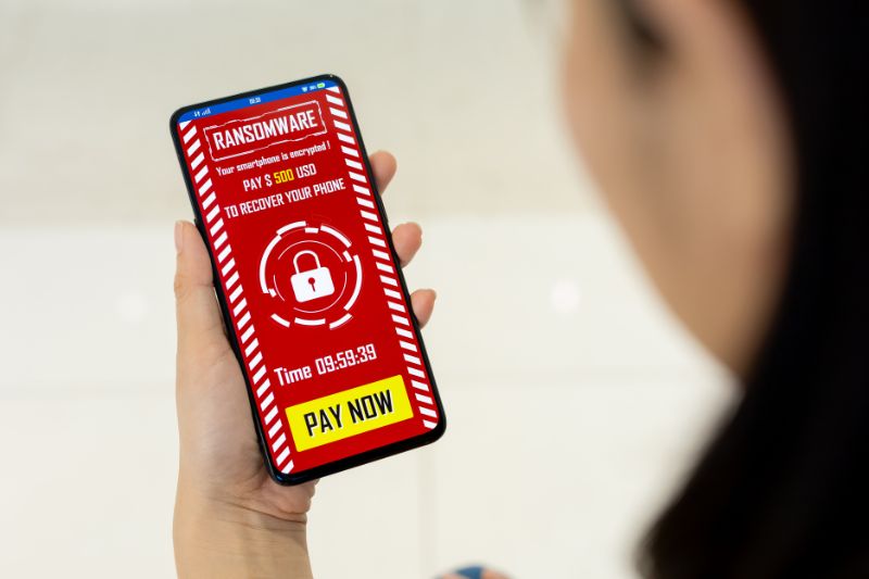 Smartphone con schermata di richiesta di riscatto visualizzata dopo un attacco ransomware. Smartphone con schermata di richiesta di riscatto visualizzata dopo un attacco ransomware.